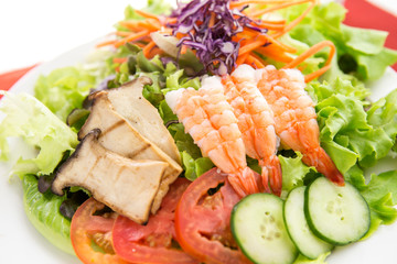 vegetable salad top with shrimps and grilled sliced oringi mushroom in white plate  served 