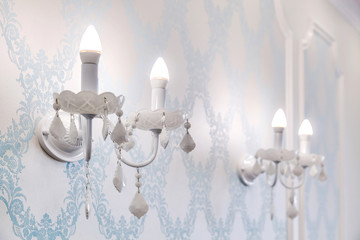 Vintage candelabra with lamps on a beautiful wall