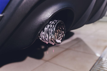 Car exhaust pipe with soap. Car wash background. close-up