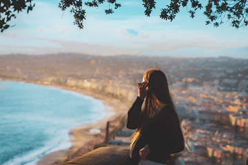 young female watching sunset in Nice, France. beautiful panoramic aerial cityscape top view of Nice, of French riviera. Landscape of harbor, town of Cote d'Azur France. woman enjoying evening near sea