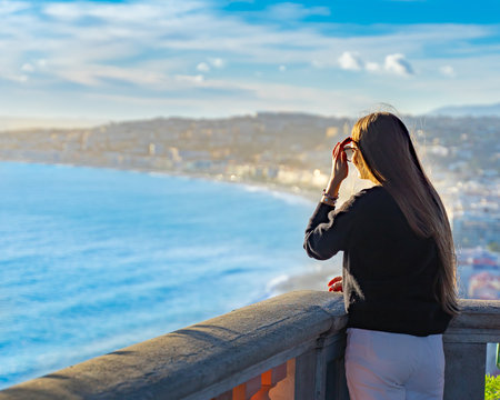 young woman watching sunset in Nice, France. beautiful panoramic aerial cityscape top view of Nice, of French riviera. Landscape of harbor, town of Cote d'Azur France. woman enjoying evening near sea.