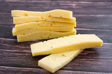 pieces of cheese on a wooden background. Close-up.