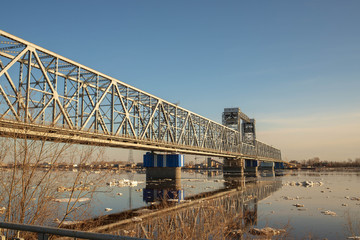 Fototapeta premium Spring evening in Arkhangelsk. Ice drift on the Severnaya Dvina river. The world's northernmost drawbridge.