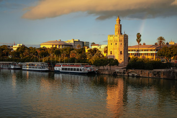 Fototapeta premium Beautiful tower of gold and Guadalquivir river at sunset in Seville, Spain