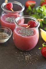 Berry smoothie with chia seeds on dark background, top view
