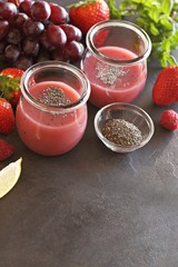 Berry smoothie with chia seeds on dark background, top view
