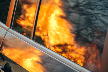 Spiegelung in Autoscheibe von brennenden Christbäumen von Weihnachten mit lodernden Flammen wie bei einem Waldbrand - Powered by Adobe