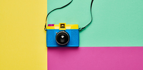 Fashion film camera. Minimal hipster summer trend flat lay. Retro design camera on vivid color....