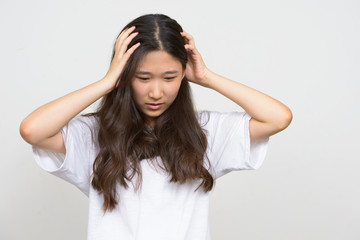 Naklejka premium Portrait of stressed young Asian woman having headache