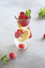 Raspberry infused water, coctail or lemonade. Summer iced cold drink with raspberry, lemon and mint. Selective focus