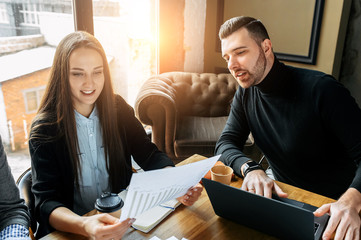 Successful business team. Young Timlid explains some documents to a girl employee