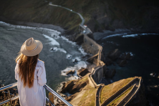 young woman standing up in San Juan de Gaztelugatxe. Sunrise