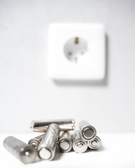 batteries lie on the background of a wall socket