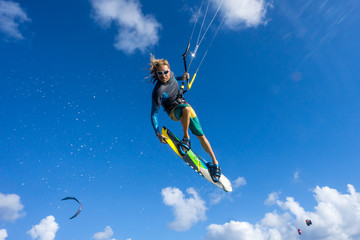 professional kiter makes the difficult trick on a beautiful background of spray and beautiful clouds of Mauritius