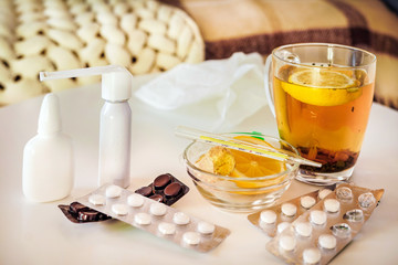 Cup of tea with ginger and lemon and pills on the table. Help from symptoms of respiratory viral infection, fever, cough, headache shortness of breath. Coronavirus ​​covid-19 epidemic pandemic concept