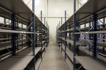 huge warehouse with empty racks inside for storage modern design, metal shelves for distribution