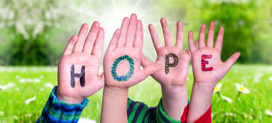 Children Hands Building Colorful English Word Hope. Sunny Green Grass Meadow As Background