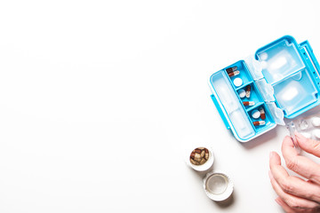 flat lay of different medicine pills in packs on white desk