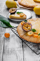 Galette with cottage cheese filling topped with kumquats, passion fruit and mint on the lattice