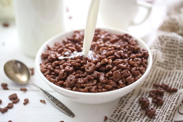 Milk is poured into chocolate balls.
Breakfast cereal