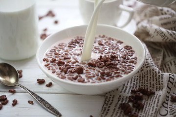 Milk is poured into chocolate balls.
Breakfast cereal