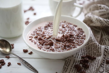 Milk is poured into chocolate balls.
Breakfast cereal