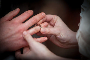 An unrecognizable bride and groom exchanging of the Wedding Rings in church during the christian wedding ceremony 