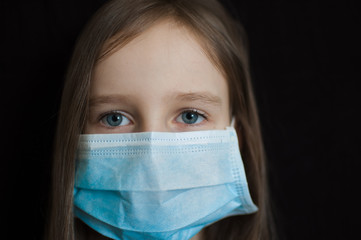 Portrait of sad girl with blue eyes is looking at the camera on black backgound in surgical...