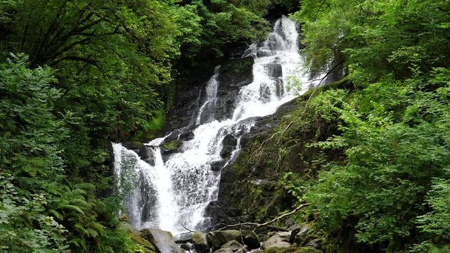 Stunning view of Torc waterfall amidst lush foliage in Ireland, county Kerry.