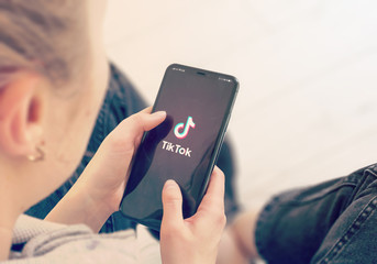 or publicitaire TikTok KYIV, UKRAINE-JANUARY, 2020: Tiktok on Smart Phone Screen. Young Girl Pointing or Texting Tiktok on Smart Phone During a Pandemic Self-Isolation and Coronavirus Prevention.