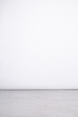 Pionowe jasne tło studyjne, kawałek podłogi betonowej. © insomniafoto