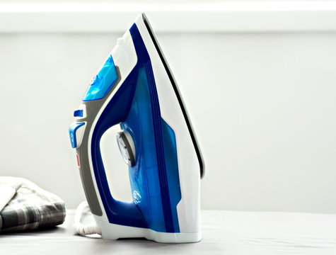 electric iron standing vertically on the Ironing Board
