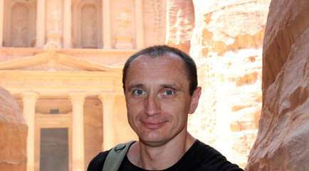 Obraz premium Smiling europian tourist man in sunglasses and black wear in Petra in Jordan during a journey.