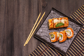 Grilled tiger prawn sushi. Japanese or Korean roll with different fresh ingredients. Trendy black background