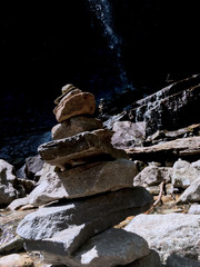 stack of balancing zen stones outside in the wild by a waterfall