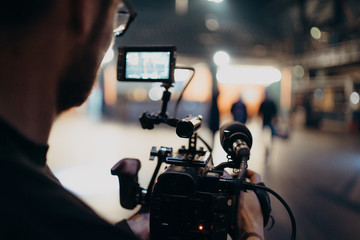 man filming inside a building