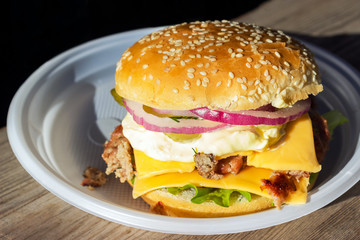 appetizing fresh homemade burger with with meat, cheese and lettuce on a wooden table. Delicious fast food concept. Copyspace
