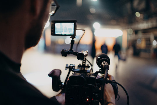 man filming inside a building