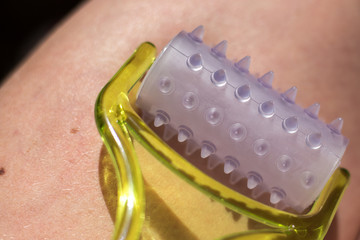 woman doing thigh massage with hand massager, exercises on self-isolation