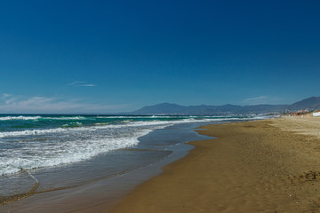 Empty beach in Marbella, Spain. Blue water, sandy beach, mountains.