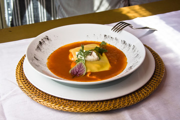 Huevos benedictinos, plato de huevos benedictinos bañados en salsa roja de tomate