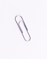 Silver office clip on a white isolated background.