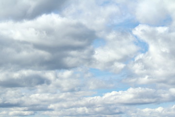 Clouds in the blue sky at sunset or dawn backlit by the sun. Place for text and design.