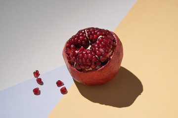 sweet fresh pomegranate on a colorful background with a hard shadow. Concept photo