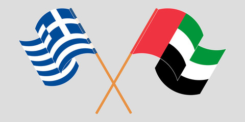 Crossed and waving flags of Greece and the United Arab Emirates