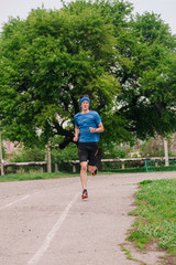young guy runs morning stadium workout