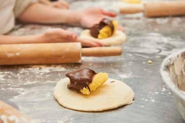 young children fill a flour product with a sweet filling. Master class baking