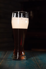 Poured beer on a dark background on a wooden table. The concept of relaxation and pastime