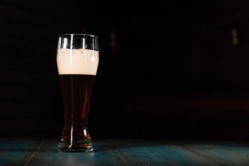Poured beer on a dark background on a wooden table. The concept of relaxation and pastime