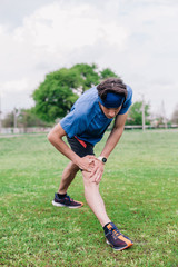 Fototapeta premium young guy does warm-up at the stadium before running